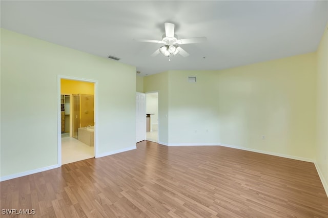 empty room with ceiling fan and light hardwood / wood-style flooring