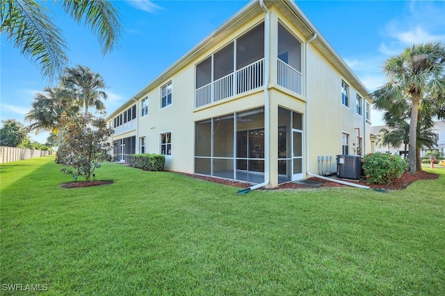 rear view of house featuring cooling unit and a lawn