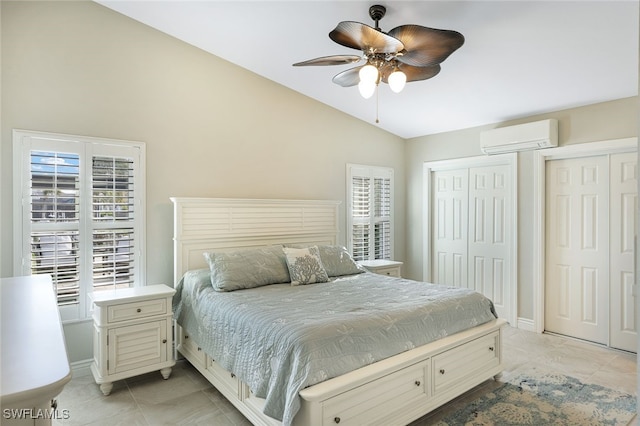 bedroom with ceiling fan, baseboards, vaulted ceiling, an AC wall unit, and multiple closets