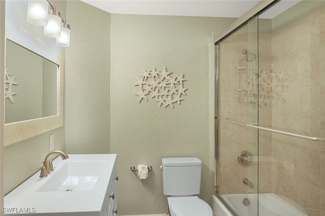 bathroom with toilet, a textured wall, bath / shower combo with glass door, and vanity