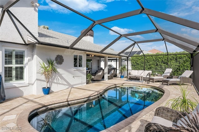 outdoor pool featuring glass enclosure, a patio, and an outdoor living space