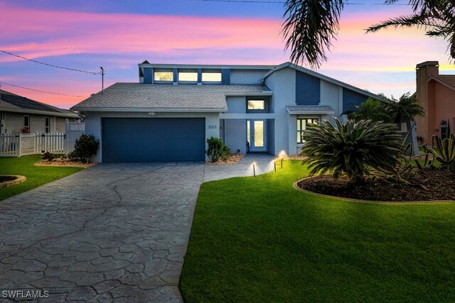 view of front of property with a garage and a yard