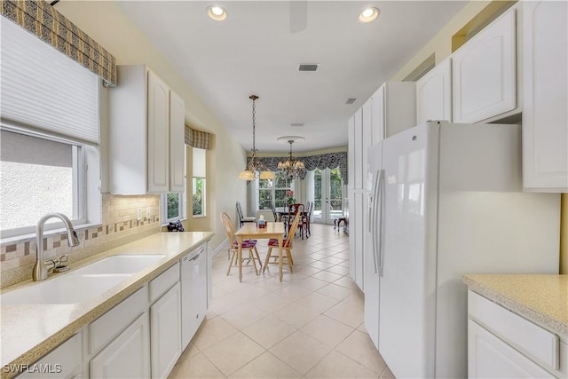 kitchen with decorative light fixtures, white appliances, and white cabinets