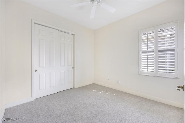 unfurnished bedroom featuring ceiling fan, a closet, and light carpet