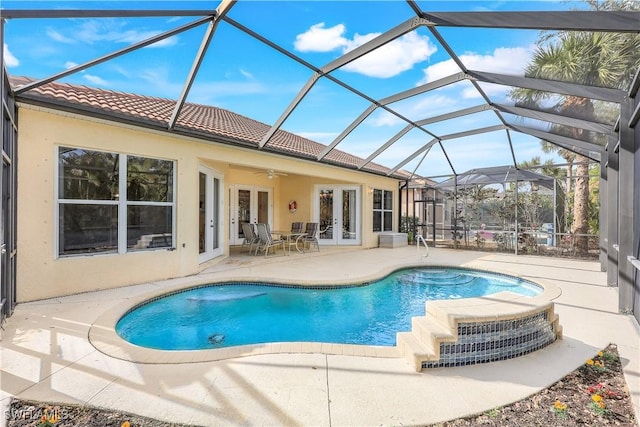 view of swimming pool featuring a patio area, ceiling fan, a lanai, and french doors