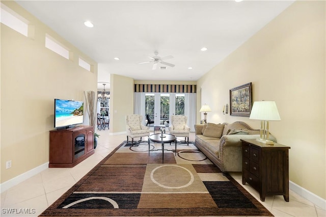 tiled living room with ceiling fan with notable chandelier