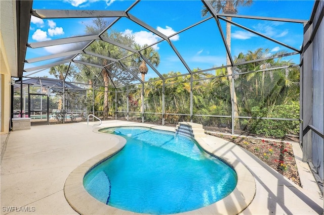 view of pool featuring glass enclosure and a patio