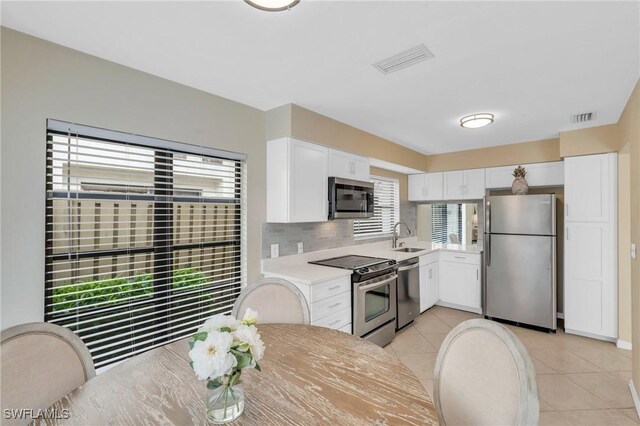833 Reef Point Cir, Naples, FL 34108 - kitchen featuring decorative backsplash, sink, white cabinets, and stainless steel appliances