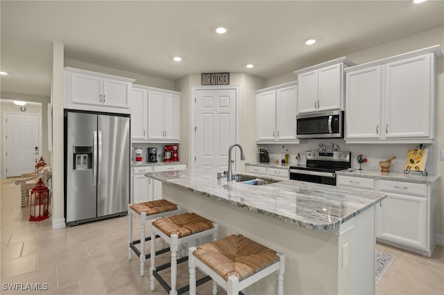 kitchen with white cabinetry, an island with sink, appliances with stainless steel finishes, and sink