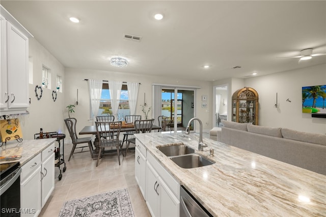 kitchen featuring light tile patterned flooring, light stone countertops, sink, and white cabinets