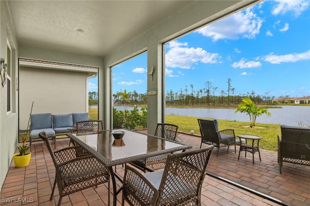 sunroom / solarium featuring a water view