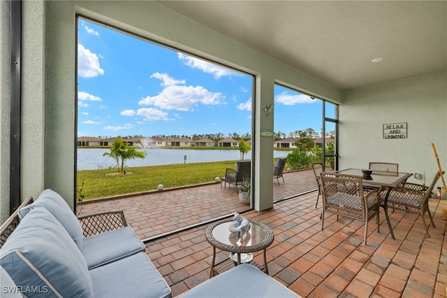 sunroom featuring a water view