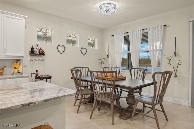 dining area with an inviting chandelier and light tile patterned flooring