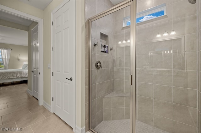 bathroom with a shower with shower door and tile patterned flooring