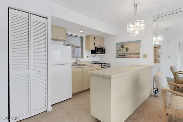 kitchen featuring sink, appliances with stainless steel finishes, light tile patterned flooring, decorative light fixtures, and cream cabinetry