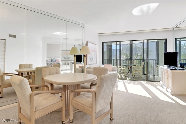 carpeted dining room with french doors