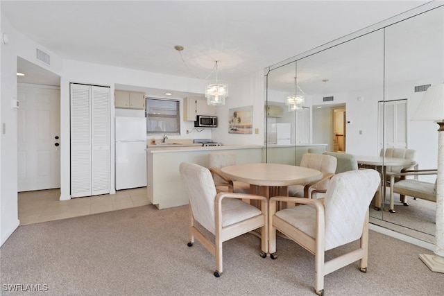 dining room featuring light carpet and sink