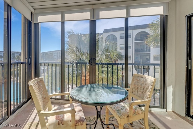 sunroom featuring a healthy amount of sunlight and a water view