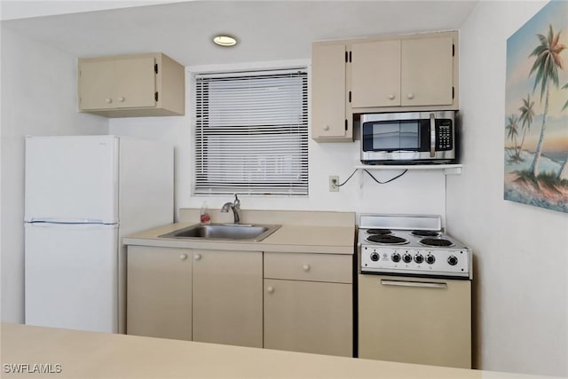 kitchen featuring white appliances, sink, and cream cabinets