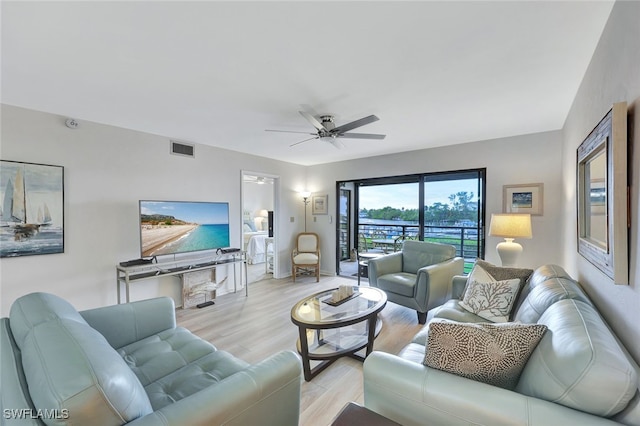 living room with light hardwood / wood-style floors and ceiling fan