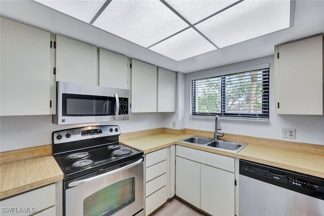 kitchen featuring appliances with stainless steel finishes, sink, and white cabinets