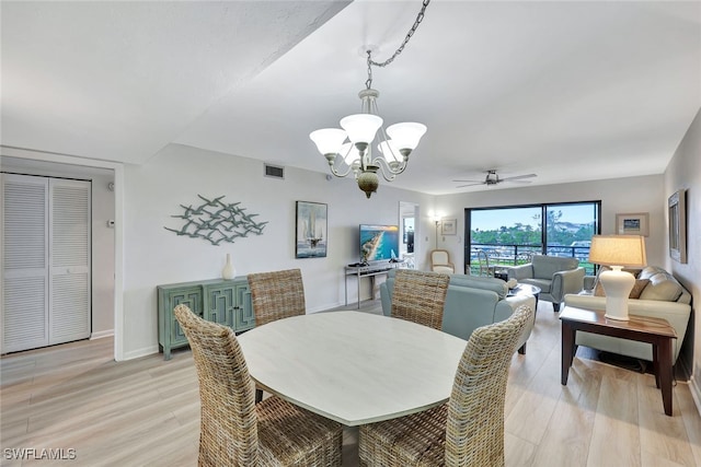 dining space with a notable chandelier and light wood-type flooring