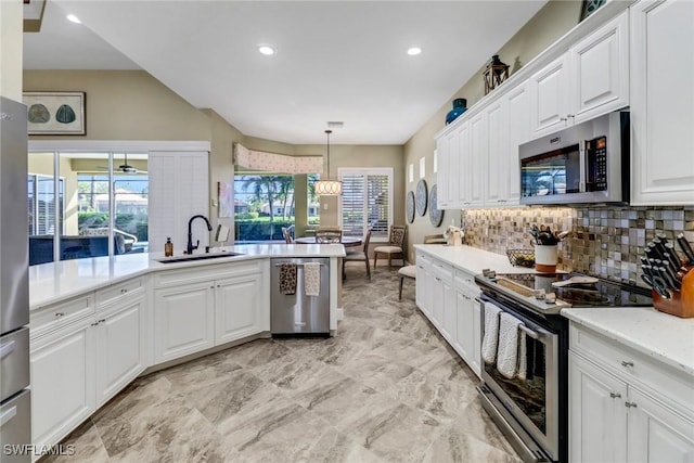 kitchen featuring white cabinetry, stainless steel appliances, backsplash, pendant lighting, and sink