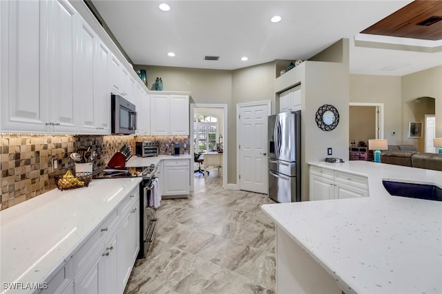 kitchen featuring light stone counters, white cabinets, and appliances with stainless steel finishes