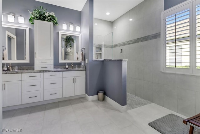 bathroom with vanity, a wealth of natural light, and a tile shower