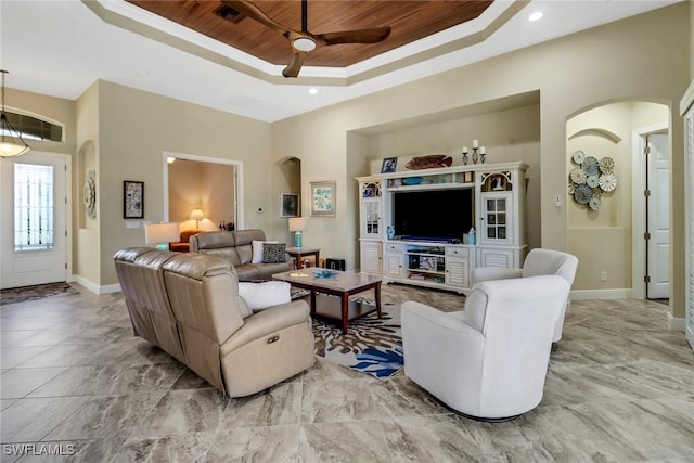 living room with ceiling fan, a tray ceiling, crown molding, and wood ceiling