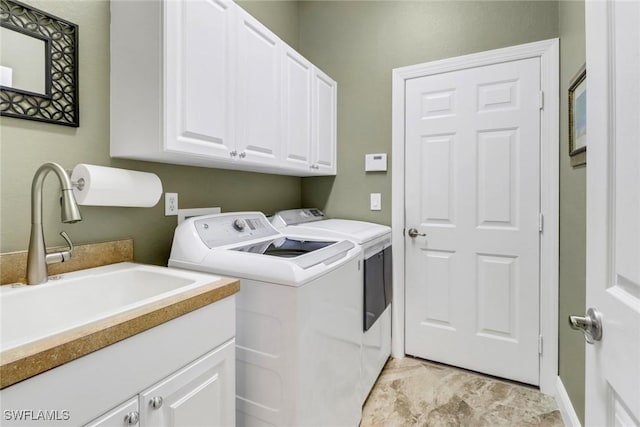 laundry area with cabinets, washer and clothes dryer, and sink