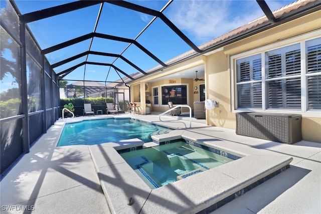 view of swimming pool featuring an in ground hot tub, glass enclosure, and a patio