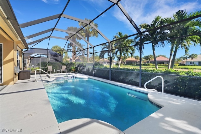 view of swimming pool with glass enclosure and a patio