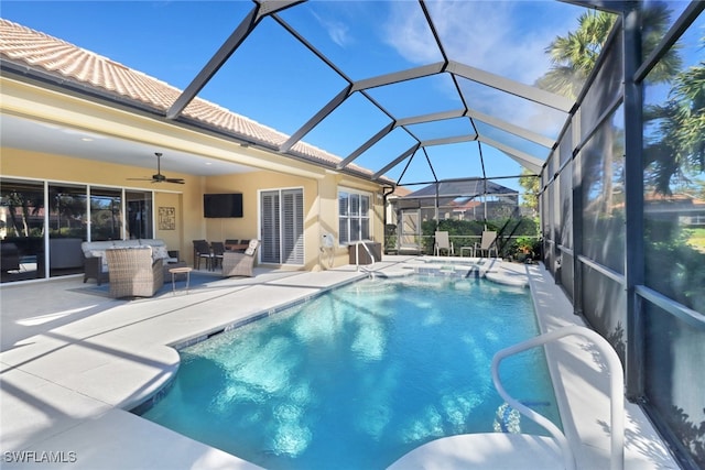 view of pool featuring glass enclosure, ceiling fan, an outdoor hangout area, and a patio