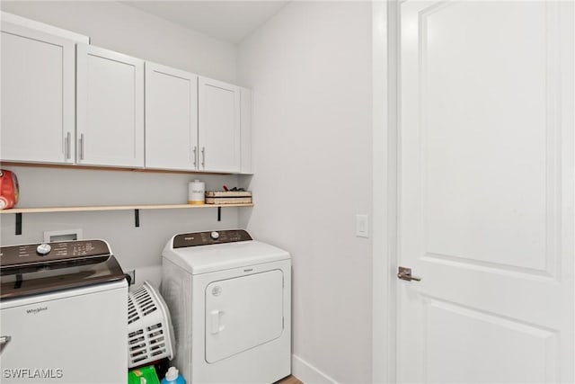 laundry room featuring cabinets and washing machine and clothes dryer