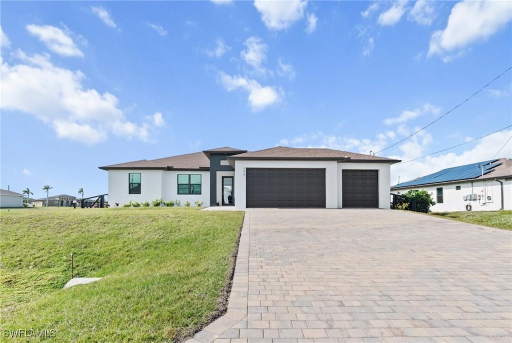 view of front of property with a garage and a front lawn