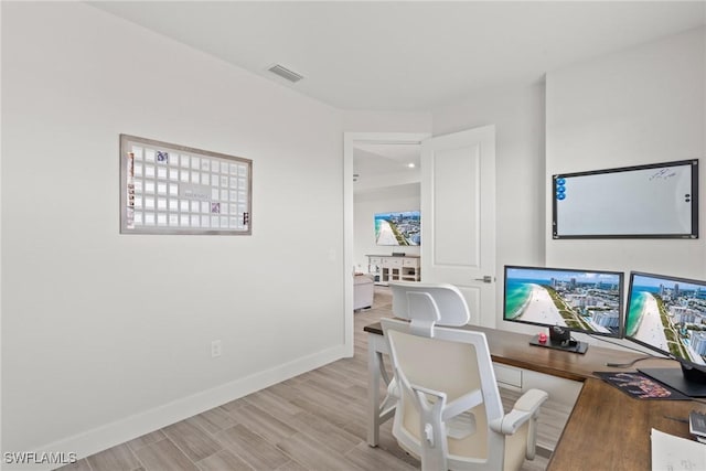 home office with light hardwood / wood-style flooring