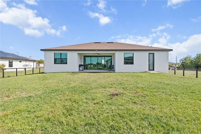 back of house featuring ceiling fan and a lawn