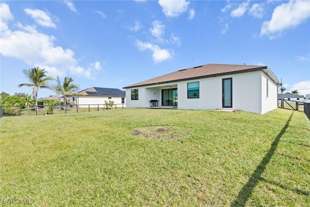 rear view of house with a yard and ceiling fan