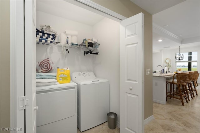 washroom with separate washer and dryer, crown molding, and sink