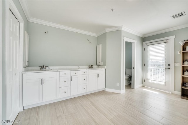 bathroom with vanity, crown molding, wood-type flooring, and toilet