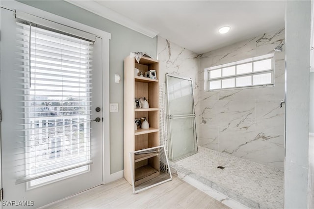 bathroom with tiled shower and ornamental molding