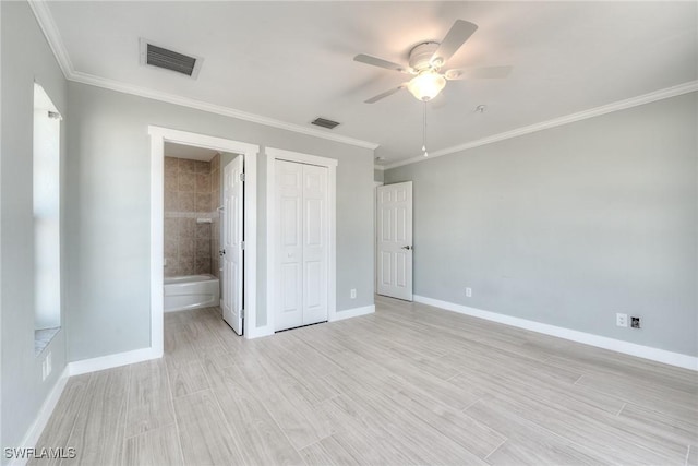 unfurnished bedroom featuring ensuite bathroom, ornamental molding, ceiling fan, light hardwood / wood-style floors, and a closet