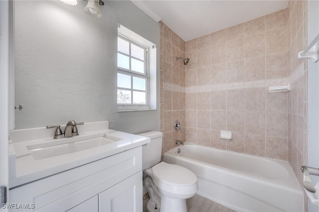 full bathroom with tiled shower / bath, vanity, and toilet