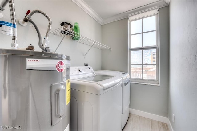 washroom with crown molding, washing machine and clothes dryer, and electric water heater