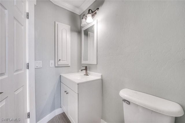 bathroom featuring vanity, crown molding, and toilet