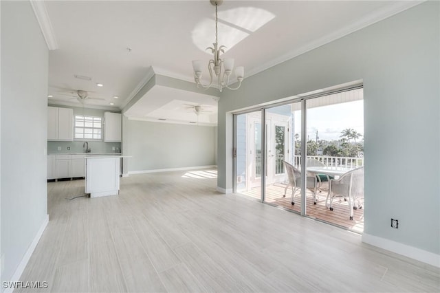 unfurnished living room featuring ornamental molding, sink, ceiling fan with notable chandelier, and light wood-type flooring