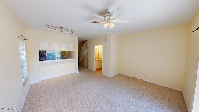 unfurnished room with light colored carpet and ceiling fan