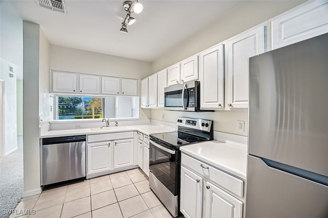 kitchen with appliances with stainless steel finishes, a sink, visible vents, and white cabinets