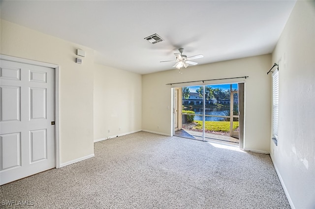 empty room with carpet, baseboards, visible vents, and a wealth of natural light